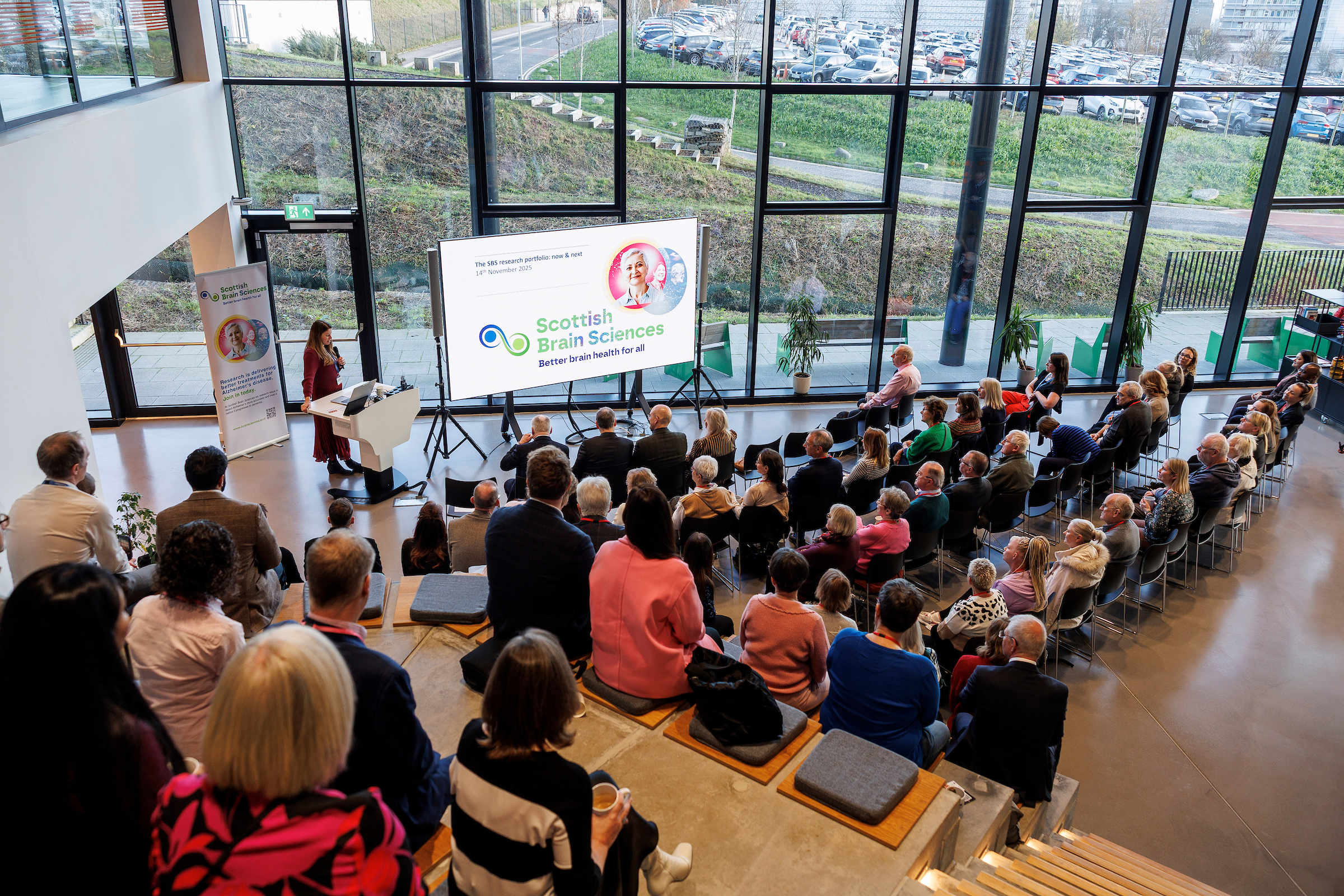 An audience of people are sitting watching a presentation