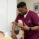 Male nurse checking blood pressure of female patient who is lying on a bed