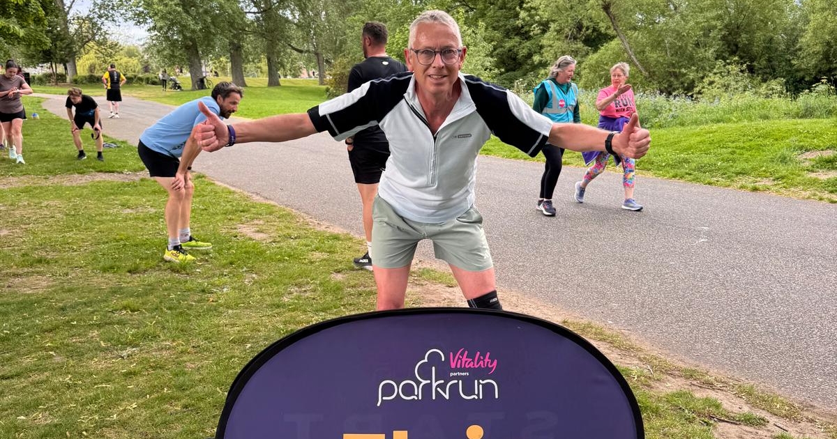 A man in running gear standing in park
